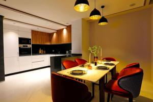a kitchen with a dining table and red chairs at Duplex de luxe, piscine sauna in Marrakech