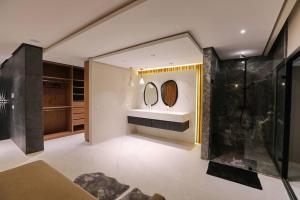 a bathroom with a sink and two mirrors on the wall at Duplex de luxe, piscine sauna in Marrakech