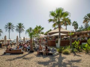 a group of people sitting in chairs on the beach at Luxurious Beachside in the Heart of Puente Romano in Marbella