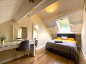 1 dormitorio con cama, escritorio y espejo en Morpeth town centre - Cottingburn House en Morpeth