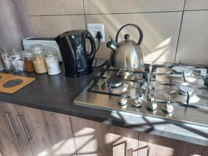 a tea kettle sitting on top of a stove at Come Home in Oudtshoorn Self-Catering Units in Oudtshoorn