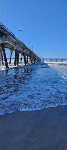 uma ponte sobre a água com uma praia ao fundo em Casa Mongagua em Mongaguá