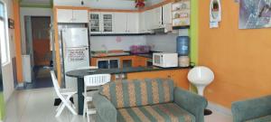 eine Küche mit einem Tisch, einem Stuhl und einem Sofa in der Unterkunft Hermoso departamento en la playa in Tonsupa