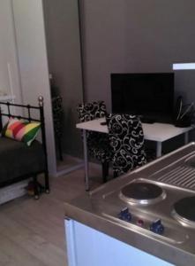 uma sala de estar com um fogão, uma mesa e cadeiras em Habitat em Senaki