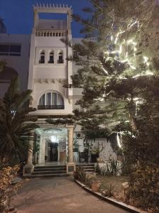 Um edifício com uma árvore de Natal à frente. em Hôtel Romane em Hammamet