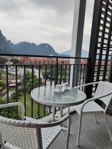 a table and chairs on a balcony with a view at Sunway Onsen 4-5pax in Kampong Batu Lapan