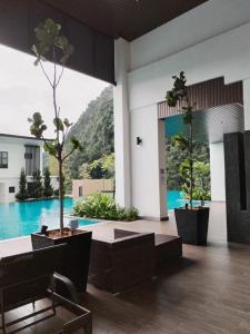 a lobby with two potted trees and a pool at Sunway Onsen 4-5pax in Kampong Batu Lapan