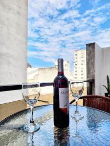 una botella de vino y dos copas de vino en una mesa en lindo departamento a 2 cuadras del obelisco en Buenos Aires