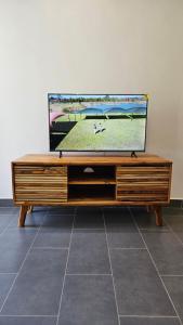a flat screen tv sitting on top of a wooden entertainment center at Starfish apartment in Paje