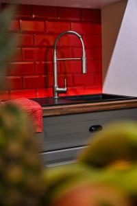 eine Küchenspüle mit einer roten Backsteinwand in der Unterkunft Il Luzzu - more room for you! in Victoria
