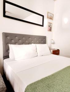 1 dormitorio con cama blanca y alfombra verde en lindo departamento a 2 cuadras del obelisco en Buenos Aires