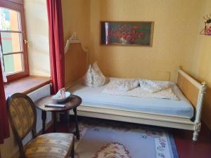a small bedroom with a bed and a table at Altes Handelshaus Plauen in Plauen
