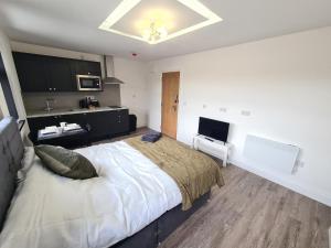 sypialnia z dużym łóżkiem i telewizorem w obiekcie Homestay by BIC Legends 2 w mieście Batley Carr