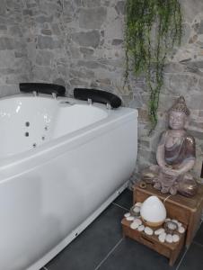 una vasca da bagno bianca con una statua accanto di Estudio jacuzzi Luz de Jerez a Jerez de la Frontera