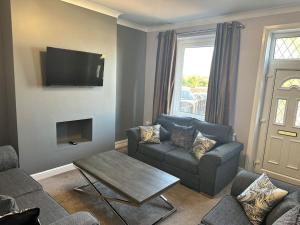 a living room with a couch and a table at Spacious 3 bed house in Wombwell in Wombwell