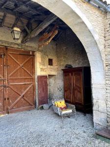 un arco con una puerta de madera y una silla en un edificio en appartement Terra Cotta, en Julienne