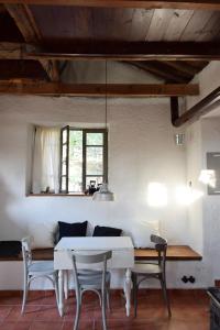 - un salon avec une table et des chaises blanches dans l'établissement Dendrocopos Medius, à Arnaia