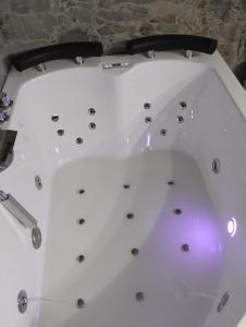 bañera en una habitación con pared de piedra en Estudio jacuzzi Luz de Jerez en Jerez de la Frontera