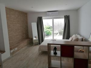 a bedroom with a bed and a large window at Tomarhousing - 37 Old Town in Tomar +18 photos
