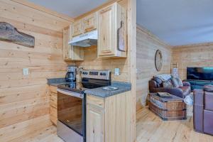 uma cozinha com armários de madeira e um forno com placa de fogão em Smoky Mountain Cabin with Camping Area and Fire Pit! em Whittier
