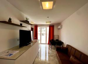 a living room with a couch and a flat screen tv at Saint Henry Sliema in Sliema