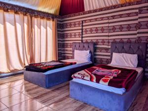 two beds sitting next to each other in a room at Wadi Rum Camp & Jeep Tour in Wadi Rum