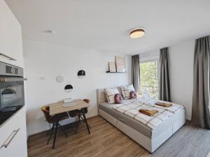 a bedroom with a bed and a table in it at TiCasa HAPPY Zentral-Outlet-Parkplatz-Aufzug-SmartTV-Unique in Metzingen
