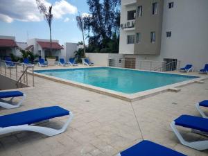 a large swimming pool with chairs and a building at Boca del Mar, Torre II, Apto. 402 in Cuevas