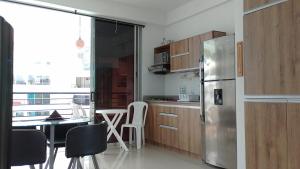 a kitchen with a table and a stainless steel refrigerator at Disfruta en Paraíso del Sol T9-402 in San Jerónimo