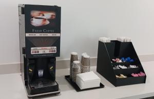 una cafetera espresso junto a una caja de asters en Red Roof Inn Lancaster, TX, en Lancaster