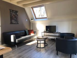 a living room with a couch and a tv at Vakantiehuis de Eekhoorn in Nunspeet op de Veluwe in Nunspeet