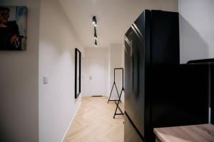 pasillo con nevera negra en una habitación en obywatelska apartament free parking, en Łódź