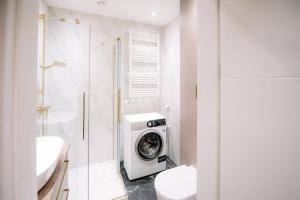 uma casa de banho com uma máquina de lavar roupa ao lado de um WC em obywatelska apartament free parking em Lódź