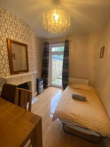 a bedroom with a bed and a table and a mirror at Nice 3 Bedroom House Ealing in London