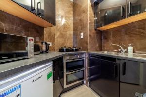 a kitchen with a sink and a microwave at Spacious 1 BDR apt - 2min to Bond Str Station in London