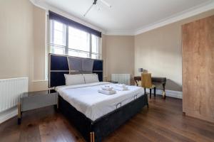 a bedroom with a large bed and a desk at Spacious 1 BDR apt - 2min to Bond Str Station in London