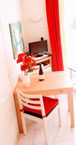 uma secretária com uma cortina vermelha e uma mesa com uma cadeira em La Victoire em Fréjus
