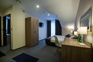 a hotel room with a bed and a desk at Jurajski Kryształ in Zaborze