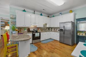 a kitchen with white cabinets and a stainless steel refrigerator at Little Inn on Main in Washington