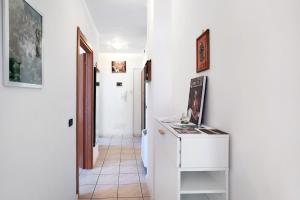a hallway with white walls and a small white cabinet at Bussana Mare in Bussana Nuova