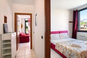 um pequeno quarto com uma cama e uma janela em Bussana Mare em Bussana Nuova