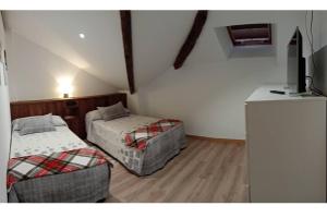 a room with two beds and a television in it at Mirador Porta da Vila, Noia in Noya