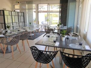 ein Restaurant mit Tischen und Stühlen in einem Zimmer in der Unterkunft Hotel Restaurant Le Jardin Délice in Saint-Victor