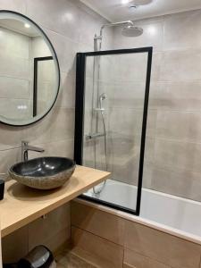 La salle de bains est pourvue d'un lavabo noir et d'une douche. dans l'établissement Maison Okaina, Sauna, Au centre-ville de Macon, à Mâcon