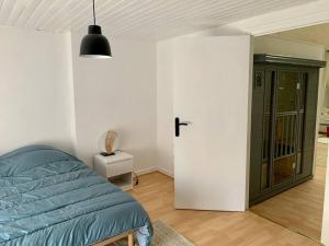 - une chambre avec un lit bleu et une porte dans l'établissement Maison Okaina, Sauna, Au centre-ville de Macon, à Mâcon