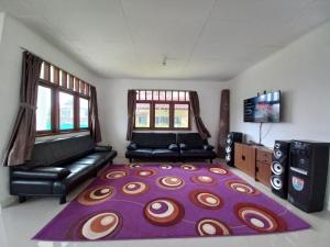 sala de estar con sofá y alfombra grande en Villa Cimacan BC 105, en Cipanas