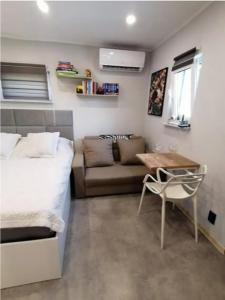 a bedroom with a bed and a couch and a table at Best Place for You in Batumi
