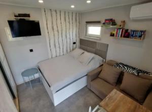 niewielka sypialnia z łóżkiem i krzesłem w obiekcie Best Place for You w mieście Batumi