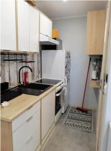 a kitchen with white cabinets and a refrigerator at Best Place for You in Batumi