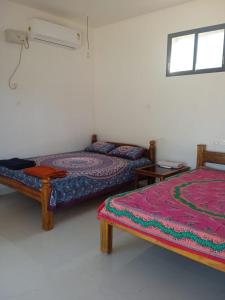 um quarto com duas camas e uma janela em Gajananstay Beach facing Rooms Indians only em Gokarn